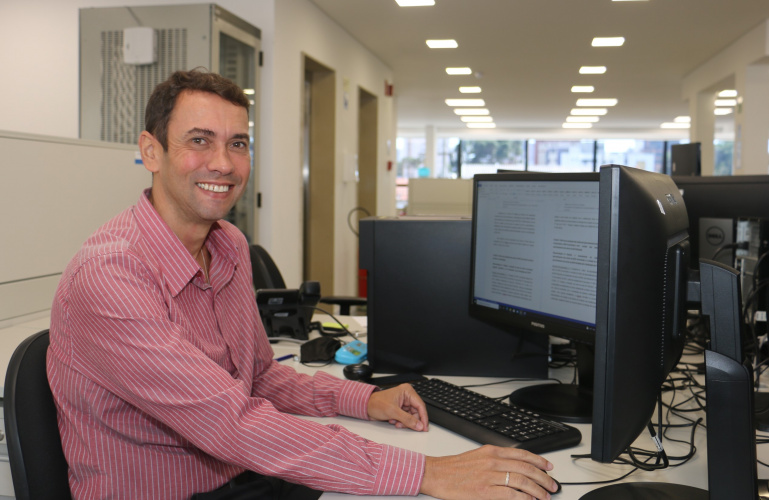 Chefe da CES em frente ao computador na estação de trabalho